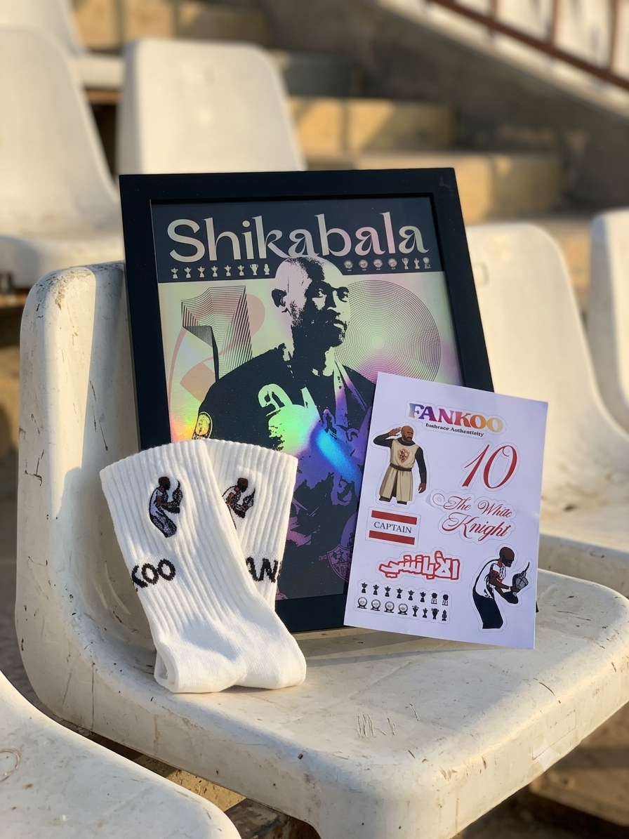 A framed Shikabala poster and a pair of white crew socks with black graphics are displayed on a white stadium seat, alongside a printed card featuring Fankoo and '10 Elites Kingdom'.
